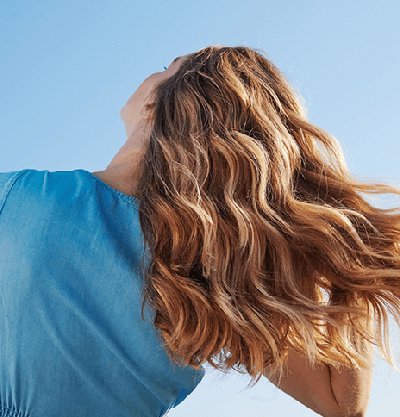 mujer pelo rubio rizado de espaldas